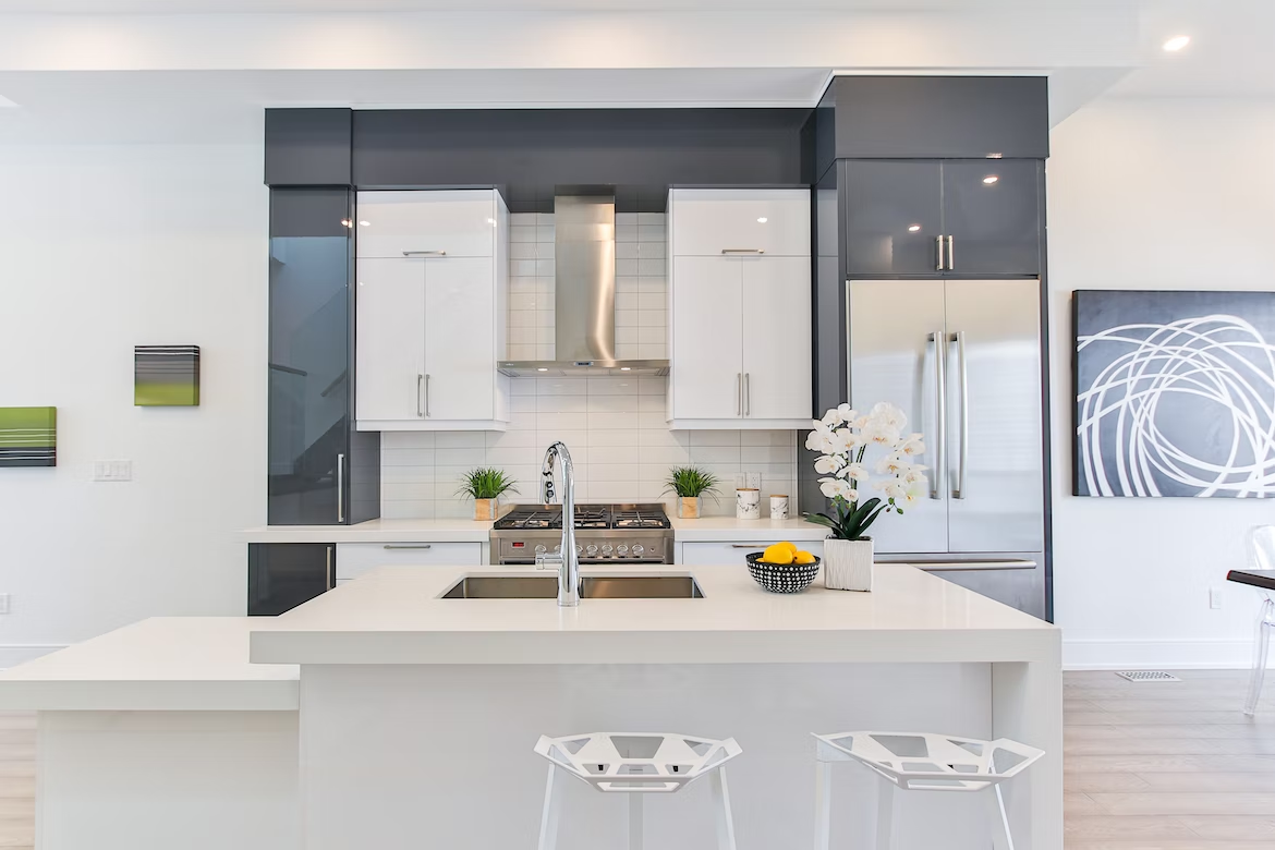A picture of a bright kitchen with white countertops and a kitchen island.